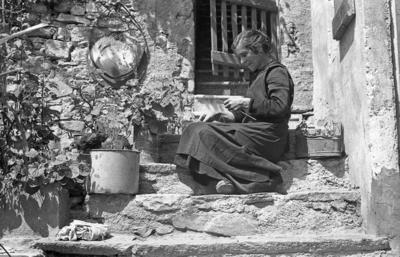 Donna che lavora a maglia sulla soglia di casa