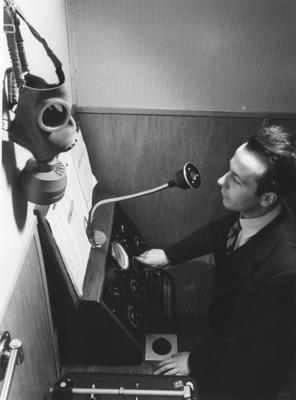 L'annunciatore Geo Molo ai microfoni della Radio svizzera con maschera antigas